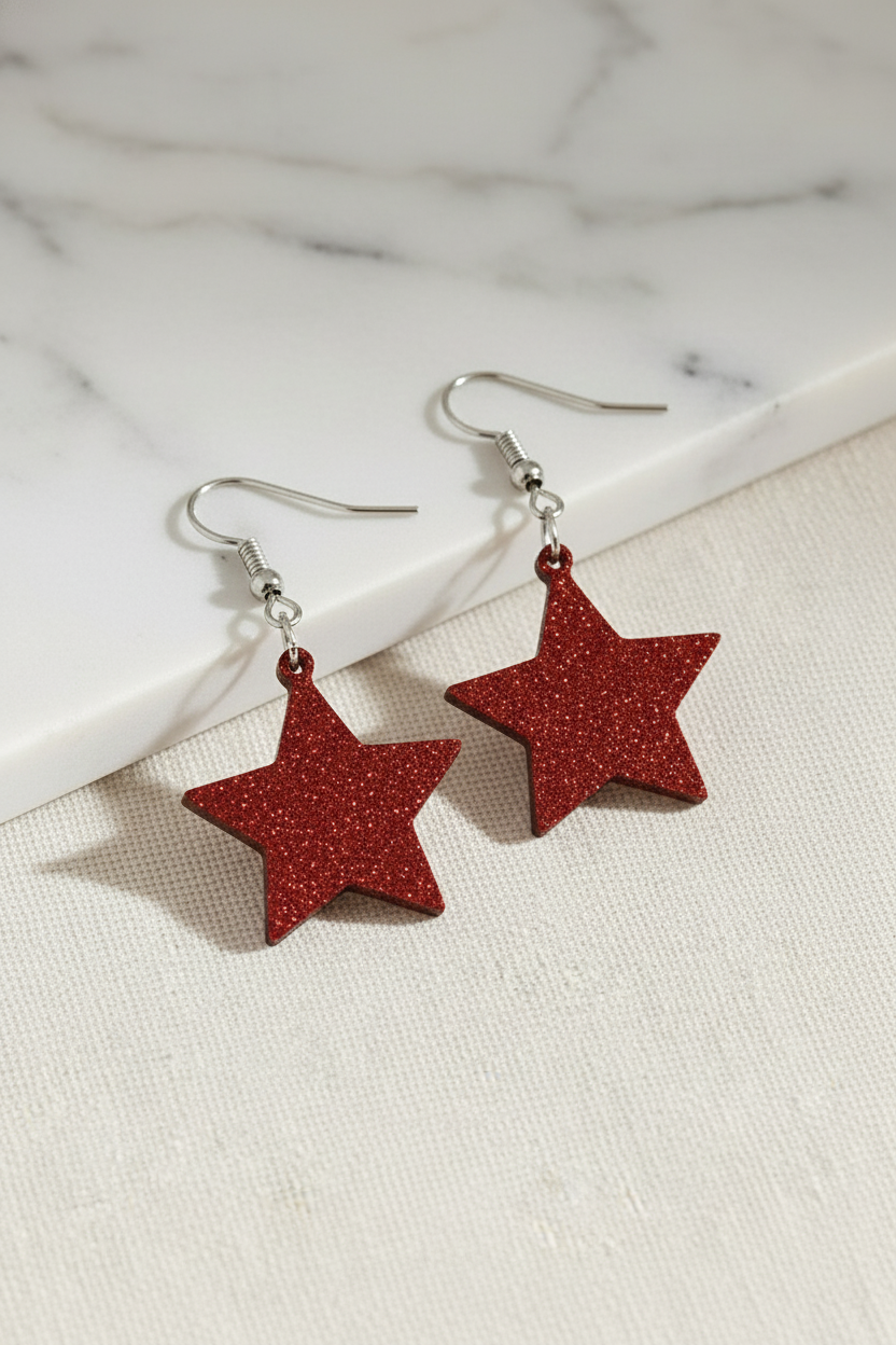 Red glitter star earring pair on professional backdrop